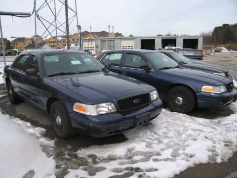 1991 Ford LTD Crown Victoria - Two Ford Crown Victoria police cars are parked in a lot with snow on the ground.