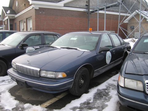 1991 Ford LTD Crown Victoria - This police car, likely a 1994 Chevrolet Caprice, is parked in a lot with snow on the ground.