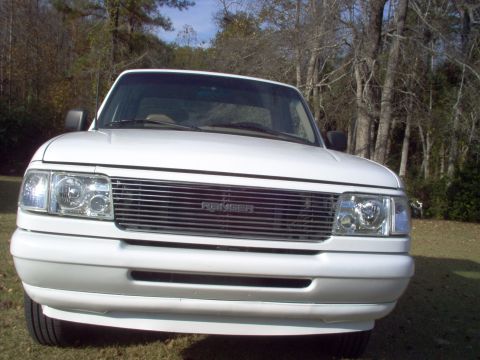 1993 Ford Ranger - Frontal view of a white 1993 Ford Ranger pickup truck parked outdoors with trees in the background.