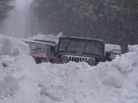 1994 Ford Explorer - Multiple vehicles are stuck in a snowdrift during a heavy snowfall.