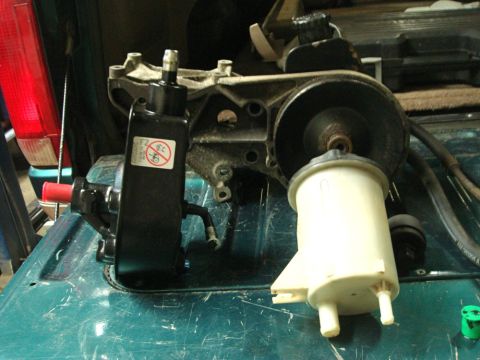 1996 Ford Bronco - Power steering pump and reservoir assembly shown with associated hoses and pulley.