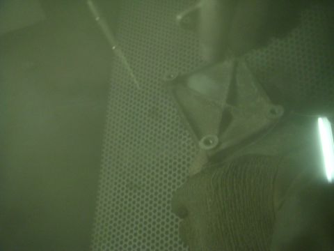 1996 Ford Bronco - A metal automotive part is shown inside a dust collector, obscuring details.