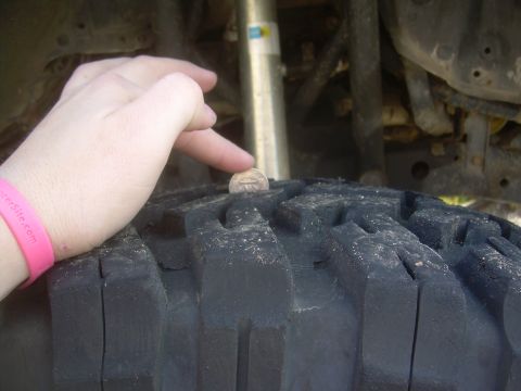 1993 Toyota 4Runner - A coin is placed on a tire to demonstrate tread depth.