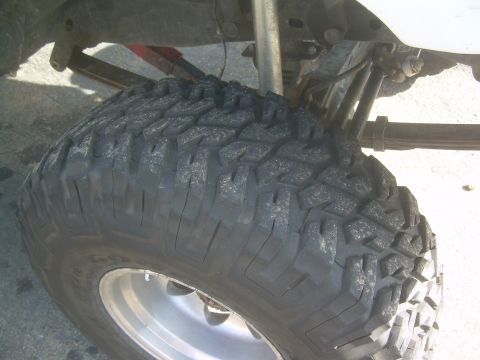 1993 Toyota 4Runner - Close-up view of an off-road tire and suspension system, with visible leaf springs and shock absorber.