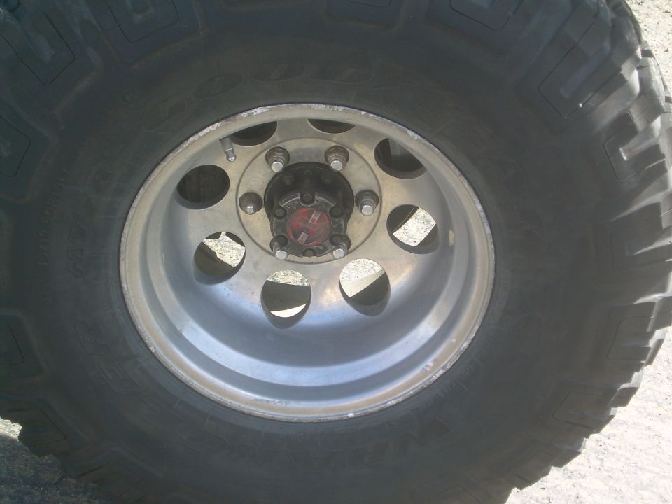 Close-up of a large off-road tire and alloy wheel with a red hub