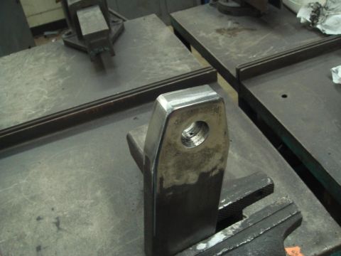 1996 Ford Bronco - A metal component with a threaded hole is secured in a vise on a workbench, ready for modification or installation.