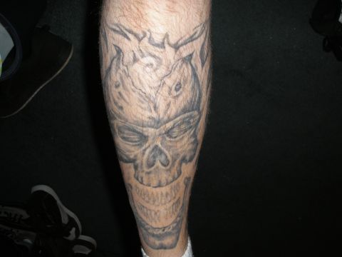 1995 Ford Bronco - A close-up view of a skull tattoo with flame-like designs on a person's leg.