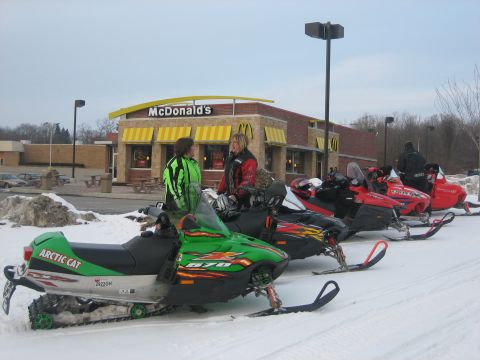 1995 Ford Bronco - Several snowmobiles are parked in the snow outside a McDonald's restaurant.
