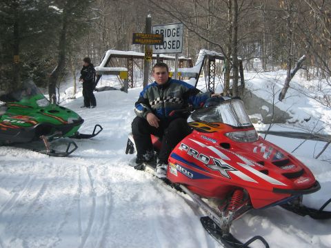 1995 Ford Bronco - Two snowmobiles are parked in the snow near a closed bridge.
