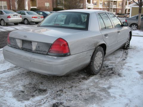 2004 Ford Crown Victoria - Rear view of a 2004 Ford Crown Victoria parked on a snowy surface.