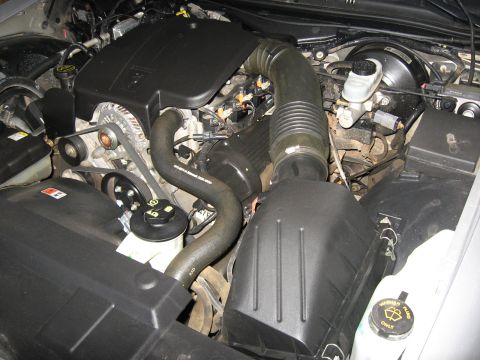 2004 Ford Crown Victoria - The engine compartment of a 2004 Ford Crown Victoria is visible, with the V8 engine, air intake, and associated components clearly depicted.