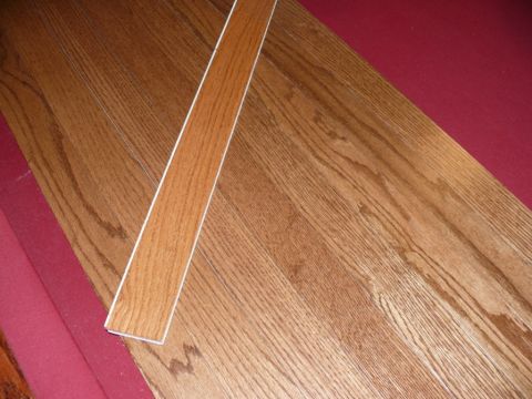 1988 Ford Bronco - Wood flooring is shown with a red carpeted edge and a strip of wood trim.