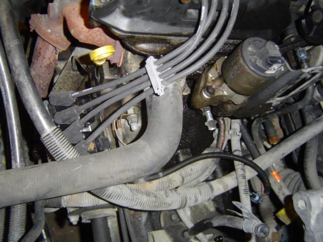 Engine bay close-up showing spark plug wires, dipstick and exhaust manifold