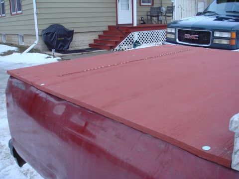 1991 Toyota Tacoma - Custom red wooden cover on a truck bed, with a GMC truck in the background.