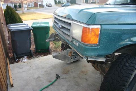 1991 Ford Bronco - The front end of a green Ford truck, possibly from the early 1990s, is shown with its bumper removed.