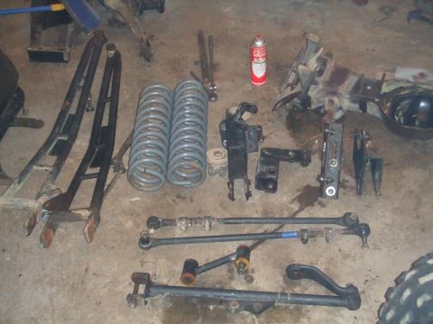 1996 Ford Bronco - Various disassembled vehicle parts are arranged on the ground, suggesting a repair or upgrade project.