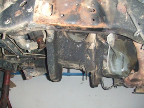 1996 Ford Bronco - The underside of a vehicle shows significant rust on the frame and suspension parts, indicating ongoing work or wear.