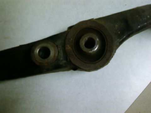 1995 Ford Bronco - Suspension control arm part with visible wear and rust on mounting points.