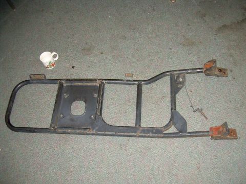1991 Ford Bronco - A metal rear bumper assembly is shown lying on a carpeted floor.