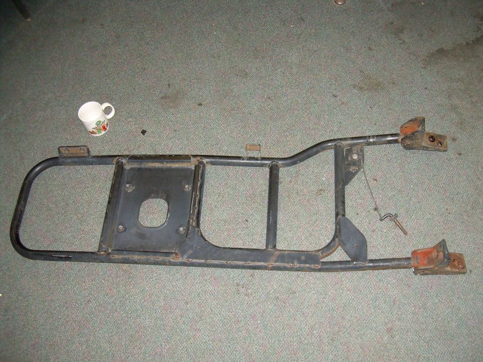 Rear bumper assembly with a mug on the floor next to it