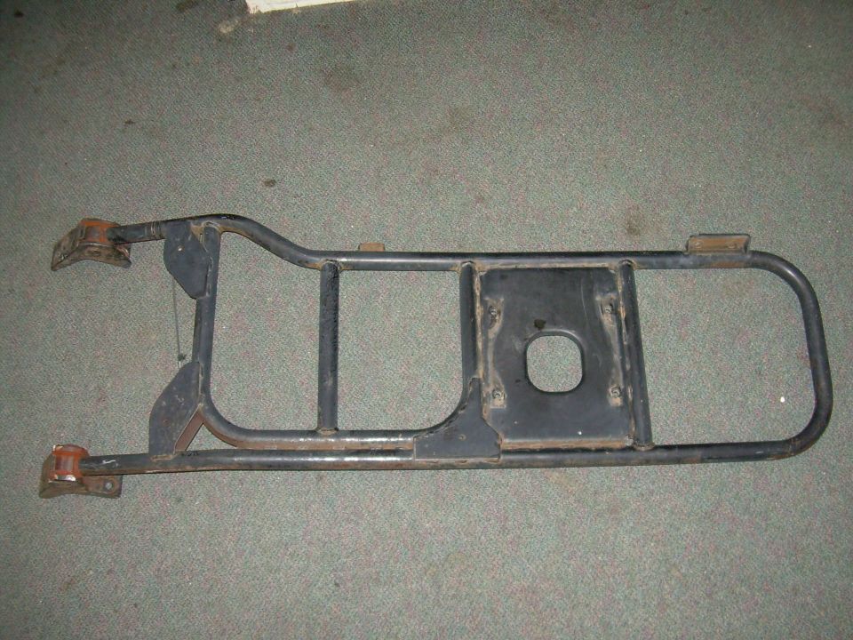 Black metal spare tire carrier with mounting brackets and a central cutout