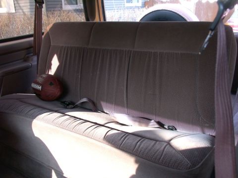 1994 Ford Bronco - Interior view of a vehicle's rear seat with a football placed on it.