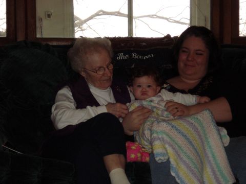 2000 Ford Crown Victoria - A grandmother, mother, and baby are seated together on a couch, sharing a tender moment.
