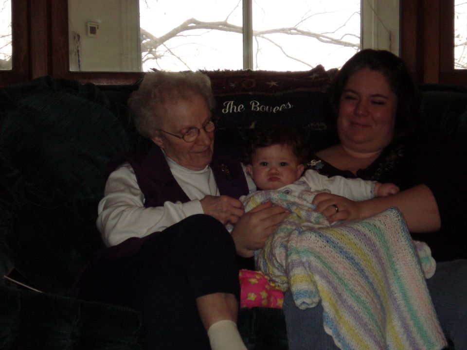 Three people, including a baby, sitting on a couch