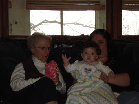 2000 Ford Crown Victoria - Three generations of women sitting together on a couch indoors.