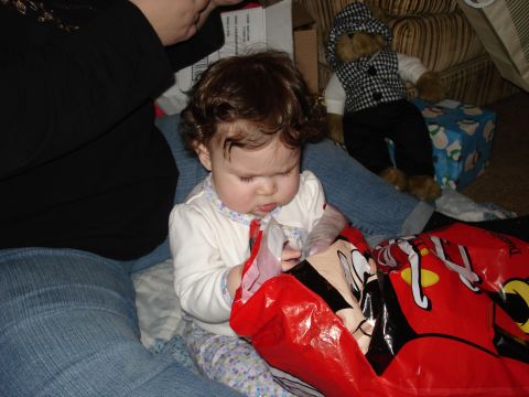 2000 Ford Crown Victoria - A baby is focused on opening a gift bag with a cartoon character on it.