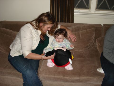 2000 Ford Crown Victoria - A woman and a baby sit on a couch, interacting with a Mickey Mouse toy.