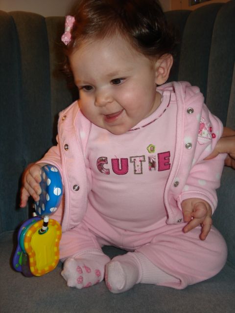 2000 Ford Crown Victoria - A baby girl smiles while playing with a colorful toy.