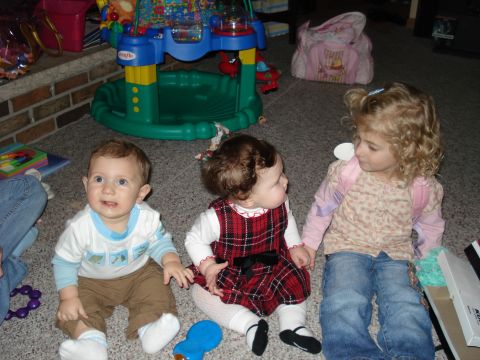 2000 Ford Crown Victoria - Three young children are gathered on the carpeted floor, surrounded by toys and playthings.