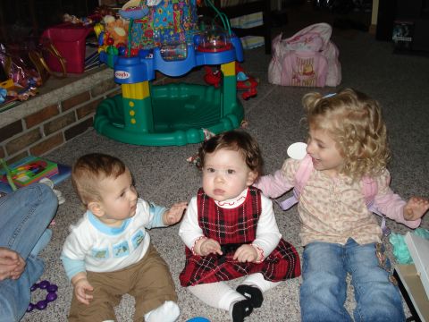 2000 Ford Crown Victoria - Three young children are gathered on the floor, surrounded by toys and play equipment.