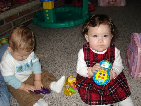2000 Ford Crown Victoria - Two young children are engrossed in play on a carpeted floor, surrounded by various toys.