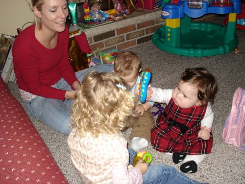 2000 Ford Crown Victoria - A woman and three children are gathered on the floor, engaged in playtime near a brick fireplace.
