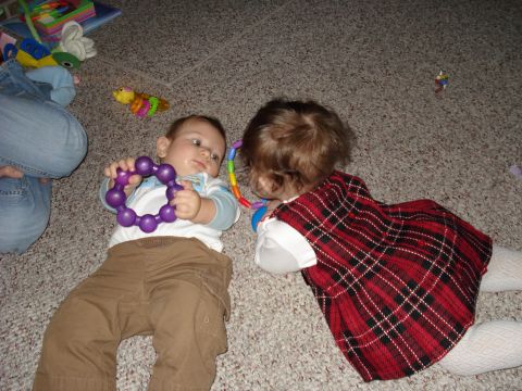 2000 Ford Crown Victoria - Two young children interact with colorful toys while lying on a carpeted surface.