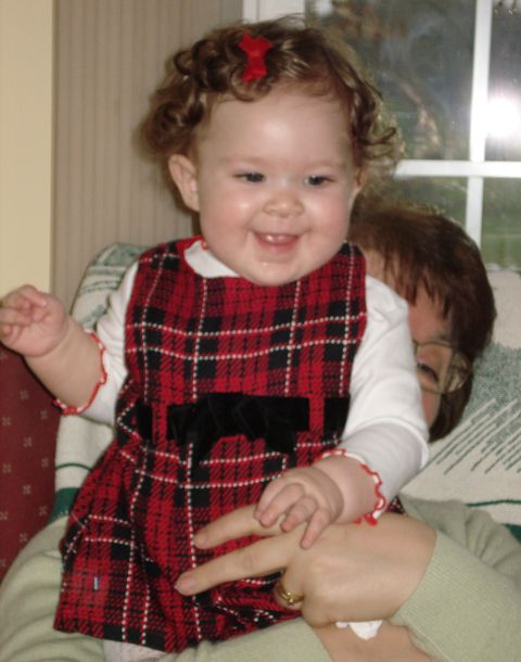 2000 Ford Crown Victoria - A smiling baby girl is held by an adult, both indoors.