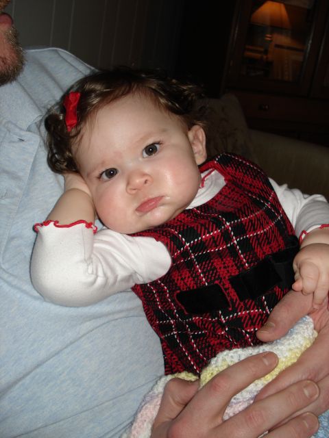 2000 Ford Crown Victoria - A baby girl wearing a red plaid dress and a white shirt looks towards the camera.