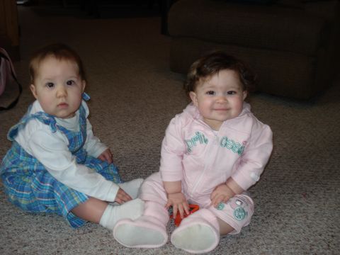 2000 Ford Crown Victoria - Two young children sit on the floor, one in blue overalls and the other in a pink tracksuit.