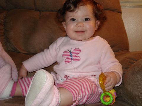 2000 Ford Crown Victoria - A baby girl sits on a couch, holding a toy.