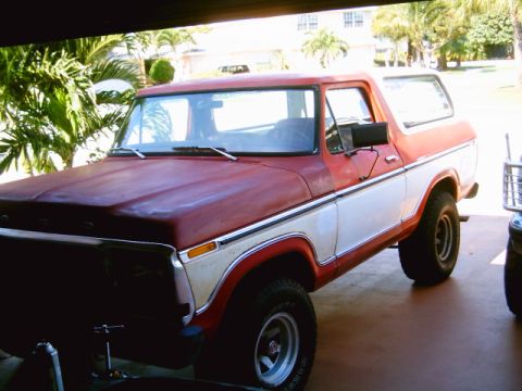 1995 Ford Bronco - This classic Ford Bronco features a distinctive two-tone red and white paint scheme with chrome trim.
