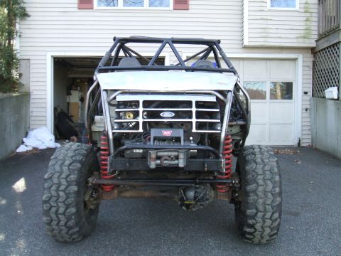 1995 Ford Bronco - This heavily modified vehicle features a roll cage and off-road tires, with a grille that resembles a 1995 Ford Bronco.