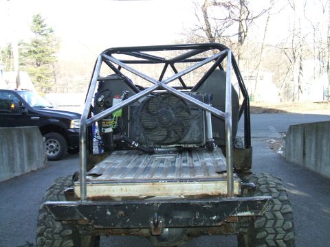 1995 Ford Bronco - This heavily modified vehicle features a prominent roll cage and a large cooling fan assembly in the rear bed area.