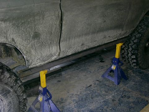 1978 Ford Bronco - Vehicle side with sliders being installed, supported by jack stands.