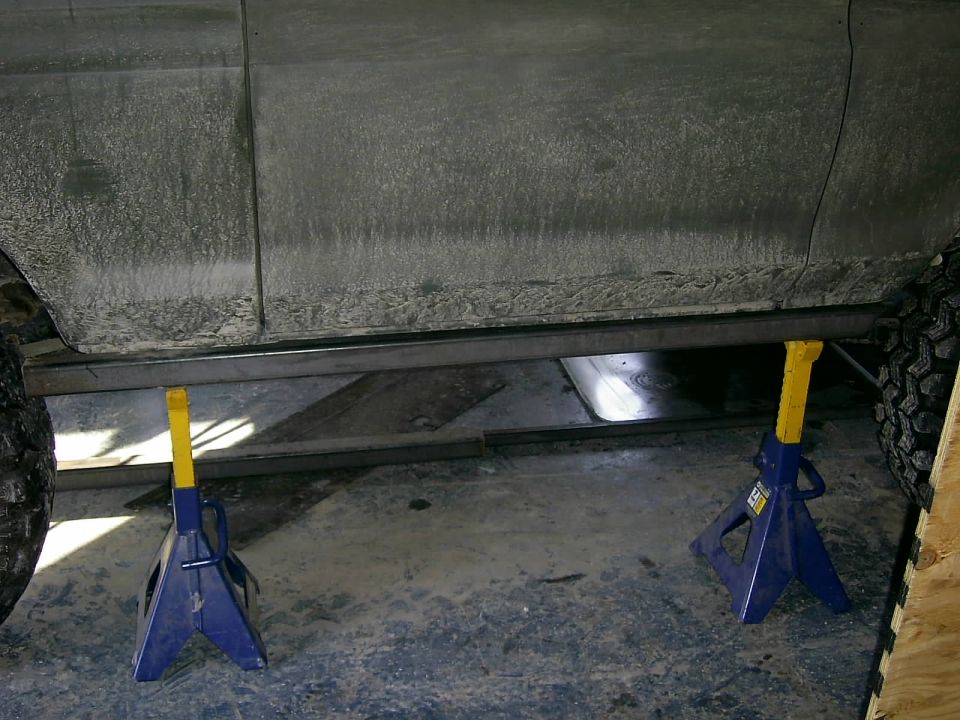 Vehicle side on jack stands, showing frame and sliders