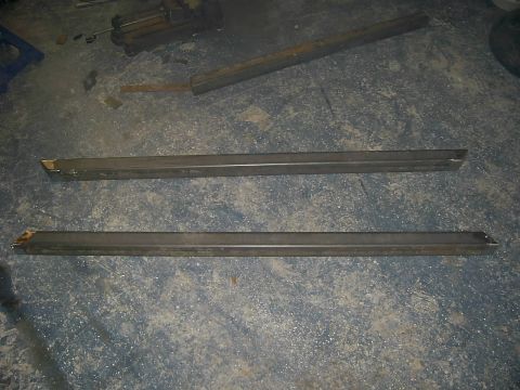 1978 Ford Bronco - Two metal sliders are shown on a concrete floor, with some tools in the background.