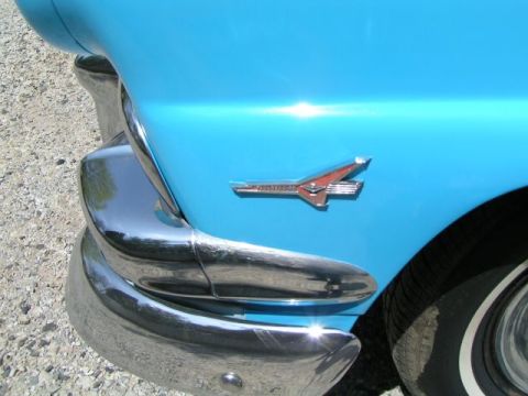 1956 Ford Fairlane - Close-up of a 1956 Ford Fairlane's fender emblem and chrome bumper.