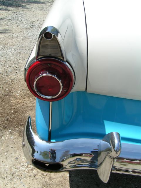 1956 Ford Fairlane - The distinctive tail light and chrome bumper of a 1956 Ford Fairlane, a two-tone white and blue paint scheme.