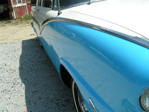 1956 Ford Fairlane - A two-tone blue and white 1956 Ford Fairlane is shown from a 3q-front angle, highlighting its distinctive body style.